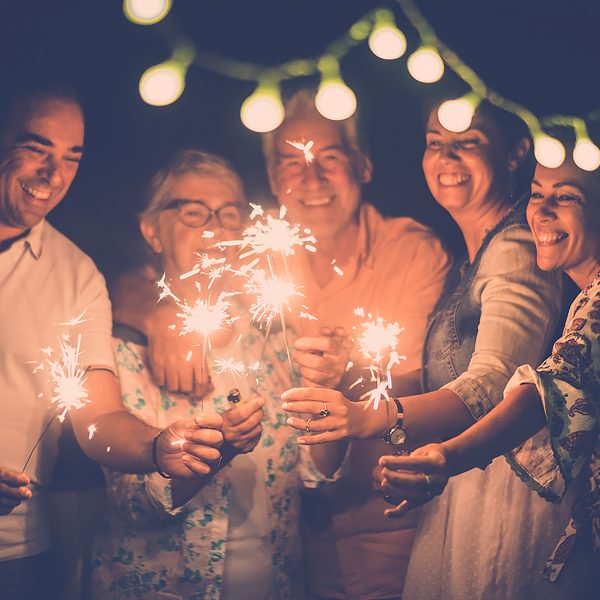 A group of smiling people holding sparklers