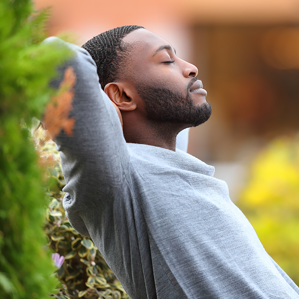 A man relaxing outside with his eyes closed