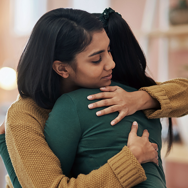 A woman comforting someone with a hug