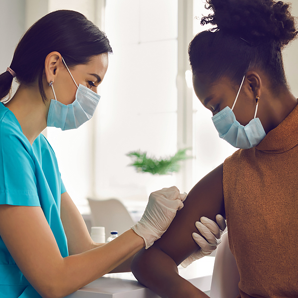 A woman receiving a vaccination from a healthcare provider