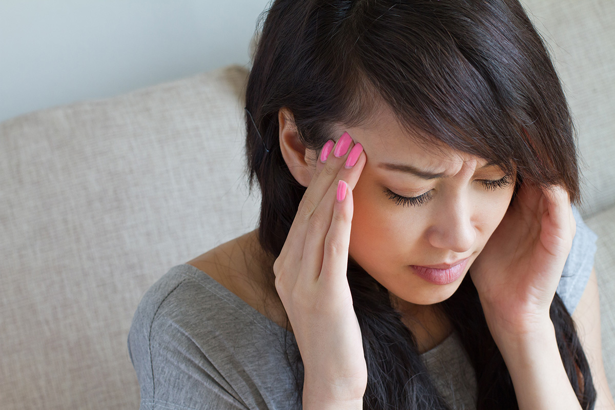 Woman holding her head in pain.