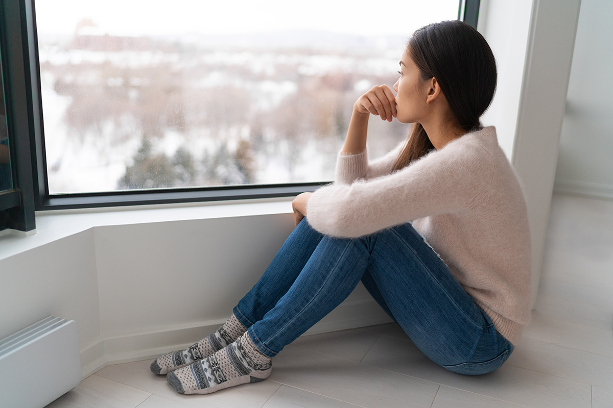 Young woman looking out the window in winter