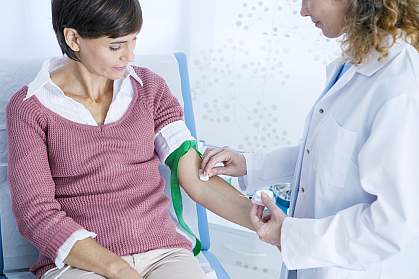 Doctor preparing a woman’s arm for a blood test.