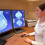 A radiology technician reviews a mammogram.
