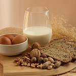  Peanuts, milk, eggs, wheat, cashews, walnuts, and hazelnuts on a wooden tray.