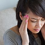 Woman holding her head in pain.